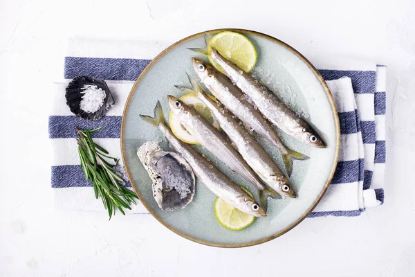 Smelt or sardine small sea fish for cooking healthy food with salt and lemon. Top view.