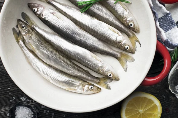 Petit poisson de mer petit éperlan, anchois sous forme de cuisson à l'huile, au sel et au citron. Espace de copie. Vue du dessus . — Photo