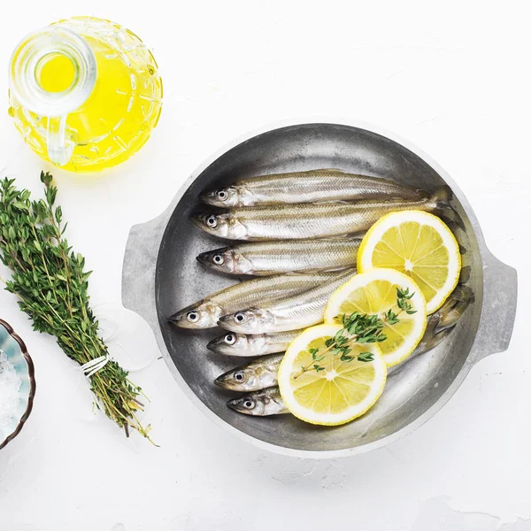 Éperlan ou sardine petit poisson de mer pour cuisiner des aliments sains avec du sel et du citron. Vue du dessus .. — Photo