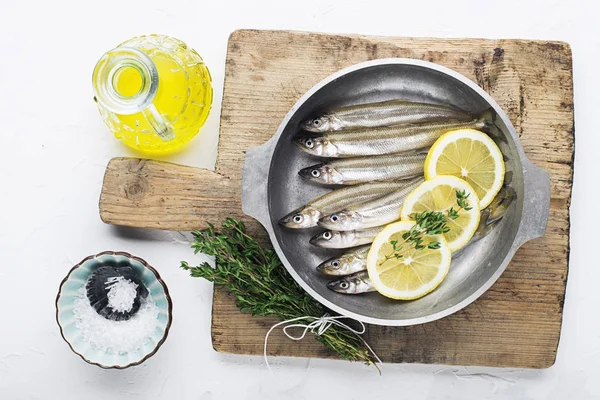 Éperlan ou sardine petit poisson de mer pour cuisiner des aliments sains avec du sel et du citron. Vue du dessus .. — Photo