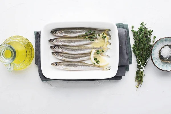 Derreter ou sardinha pequenos peixes marinhos para cozinhar alimentos saudáveis com sal e limão. Vista superior .. — Fotografia de Stock