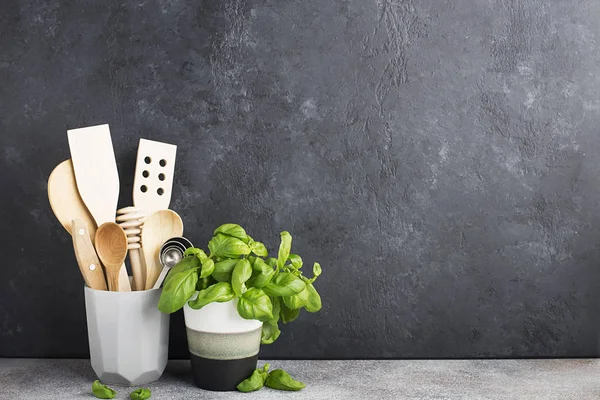 Estante de la cocina. Electrodomésticos para la cocina en un soporte moderno gris, albahaca en una taza gris en el fondo de una pared de hormigón gris. Horizontal, espacio . Fotos De Stock Sin Royalties Gratis