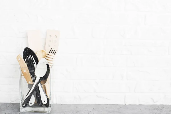 厨房用具 橄榄色的切割板上的厨房架子上靠着白色的砖墙 选择性对焦 新鲜罗勒和柠檬 白色和黑色的现代餐具 没有塑料房子 — 图库照片
