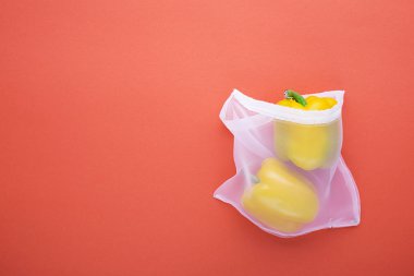 Sıfır bir parlak renkli mercan arka plan üzerine ince kumaş doğal torbalarda alışveriş sebze atık. Üstten Görünüm. Uzay kopyalayın. Yatay