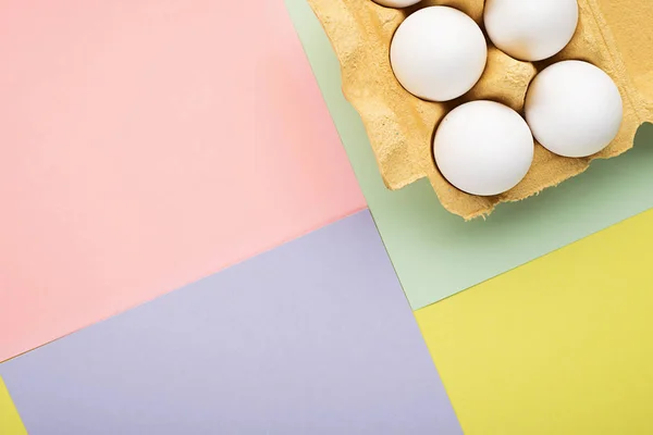 Molte uova per Pasqua in un contenitore su sfondo color pastello. Il concetto della tendenza principale. Copia spazio . — Foto Stock