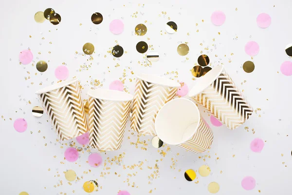 Konfeti, kağıt moda bardak beyaz zemin üzerine evrensel popüler festival arka plan pembe altın. Kavram herhangi parlak proje eğlenceli. Yatay, kopya alanı,