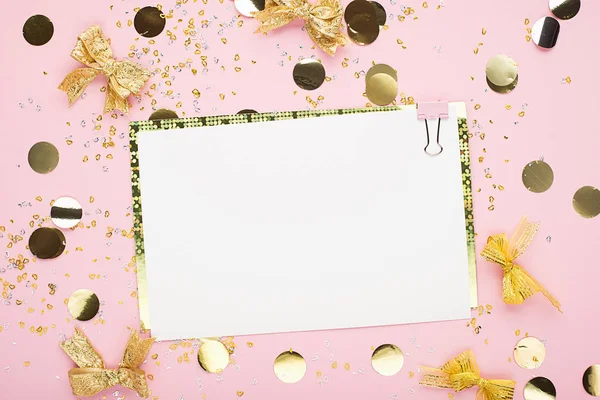 Blank sheet of paper, notebook on a festive pink background with golden confetti and glitter. Universal background for a project of a birthday party, wedding. Flay lay, copy space — Stock Photo, Image