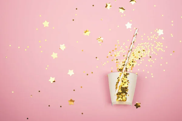 Złota złotych gwiazd na różowym tle w papierowy kubek. Gwiazda koktajl na wakacje. Pozioma, płaska świeckich, miejsce, — Zdjęcie stockowe