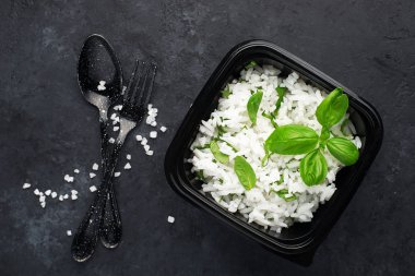 Pirinç sağlıklı bir diyet için zencefil ve fesleğen ile hazır. Karanlık bir arka plan üzerinde yukarıdan görüntüleyin. Vejetaryen diyet yemeği