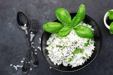 Pirinç sağlıklı bir diyet için zencefil ve fesleğen ile hazır. Karanlık bir arka plan üzerinde yukarıdan görüntüleyin. Vejetaryen diyet yemeği