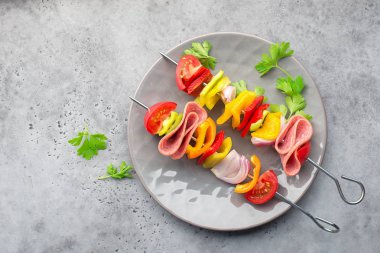 Sağlıklı atıştırmalık. Biber, mor soğan, domates, sosis ile Şişler.