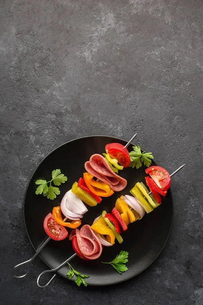 Une collation saine. Brochettes aux poivrons, oignons violets, tomates, saucisses . — Photo