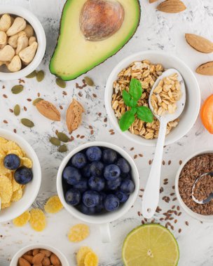 Sağlıklı bir kahvaltı için Malzemeler, fındık, yulaf ezmesi, keten tohumu, kurutulmuş meyve, avokado, yumurta, quinoa, mısır gevreği, çilek, meyve, yaban mersini, badem ceviz mevsiminde doğal organik gıda kavramı