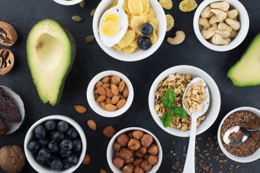 Sağlıklı bir kahvaltı için Malzemeler, fındık, yulaf ezmesi, keten tohumu, kurutulmuş meyve, avokado, yumurta, quinoa, mısır gevreği, çilek, meyve, yaban mersini, badem ceviz mevsiminde doğal organik gıda kavramı