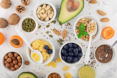 Sağlıklı bir kahvaltı için Malzemeler, fındık, yulaf ezmesi, keten tohumu, kurutulmuş meyve, avokado, yumurta, quinoa, mısır gevreği, çilek, meyve, yaban mersini, badem ceviz mevsiminde doğal organik gıda kavramı