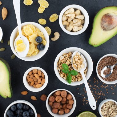 Sağlıklı bir kahvaltı için Malzemeler, fındık, yulaf ezmesi, keten tohumu, kurutulmuş meyve, avokado, yumurta, quinoa, mısır gevreği, çilek, meyve, yaban mersini, badem ceviz mevsiminde doğal organik gıda kavramı