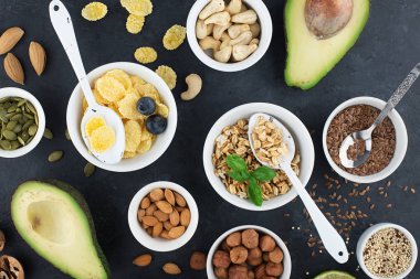 Sağlıklı bir kahvaltı için Malzemeler, fındık, yulaf ezmesi, keten tohumu, kurutulmuş meyve, avokado, yumurta, quinoa, mısır gevreği, çilek, meyve, yaban mersini, badem ceviz mevsiminde doğal organik gıda kavramı
