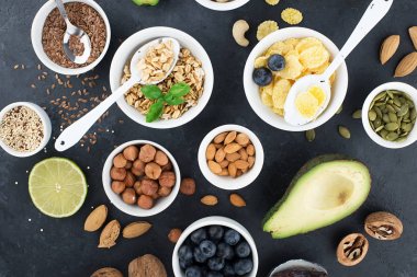 Sağlıklı bir kahvaltı için Malzemeler, fındık, yulaf ezmesi, keten tohumu, kurutulmuş meyve, avokado, yumurta, quinoa, mısır gevreği, çilek, meyve, yaban mersini, badem ceviz mevsiminde doğal organik gıda kavramı