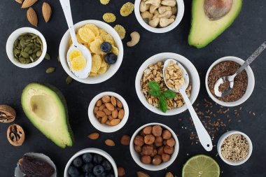 Sağlıklı bir kahvaltı için Malzemeler, fındık, yulaf ezmesi, keten tohumu, kurutulmuş meyve, avokado, yumurta, quinoa, mısır gevreği, çilek, meyve, yaban mersini, badem ceviz mevsiminde doğal organik gıda kavramı