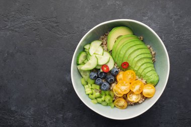Sağlıklı sebze kepekli kase. Kinoa, avokado, kiraz domatesleri, sulu kereviz, yabanmersini, acı biber, dengeli öğle yemeği kahvaltısı. Et olmadan. Üst görünüm