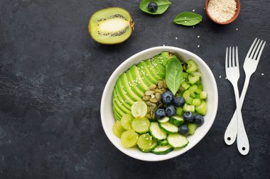 Yeşil sebze arınması salata kasesini dengeliyor. Avokadolar, salatalıklar, kiraz domatesleri, yabanmersini, kereviz, üzüm. Etsiz sulu kremalı çıtır.