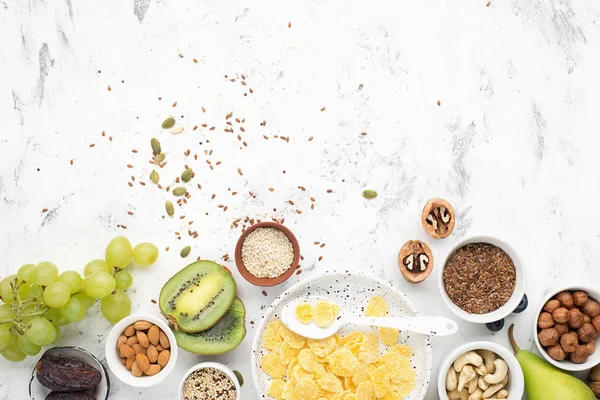 Ingredienser för en hälsosam frukost med hela korn frukost i nötter, frukter, bär, cornflakes, müsli, Super Food, quinoa, linfrön, blåbär, vindruvor. — Stockfoto