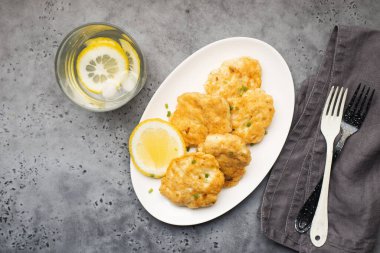 Beyaz tabakta patates kızartmalı ev yapımı balık köftesi.
