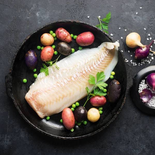 Dorsz białe ryby ziemniaki składniki naczynia dla zdrowego komfortowego domowego jedzenia. Surowy filet z białej ryby w naczyniu do pieczenia na ciemnym tle. Widok z góry., Obrazy Stockowe bez tantiem