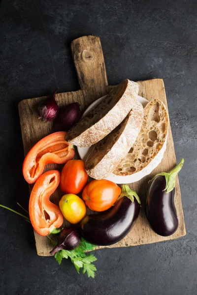 Bread salad with eggplants, tomatoes, onions, capsicum ingredients for fresh preparation. Comfortable simple meal for the whole family. Top view. Flat lay, — Stock Photo, Image