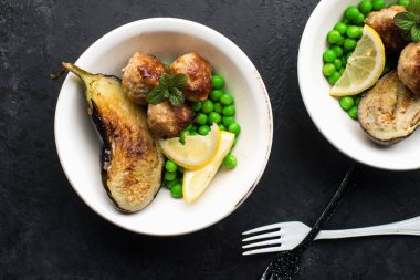Öğle yemeğinde kızarmış patlıcan ve garnitür olarak taze bezelye ile köfte. Sağlıklı atıştırmalık dengeli diyet. Üst görünüm