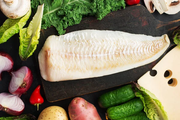 Bacalhau ingredientes de comida sãos simples: peixe branco, verduras, cogumelos, saladas folhosas verdes, cebolas, repolho, couve, pimentas quentes em um contexto leve. Deitado. Vista superior — Fotografia de Stock