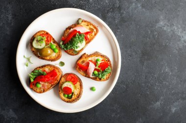Parmak yiyeceği. Çörek, bezelye, domuz pastırması, lahana ve marul ile birlikte iştah açıcı crostini. Üst görünüm