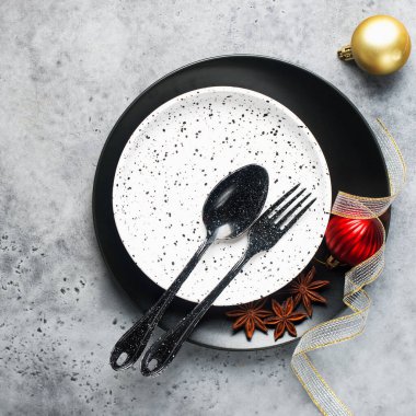 Noel masası, siyah ve kırmızı minimalizm tarzını siyah ve siyah çatal bıçaklı gri bir arka plana yerleştirdi. Üst görünüm.