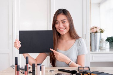 Asya genç kadın blogger hediye hediye fan kanalı ile makyaj kozmetik vlog video kaydederken aşağıdaki Anasayfa online etki unsuru concept.live viral.mock blackboard tasarımınız için yukarı akış