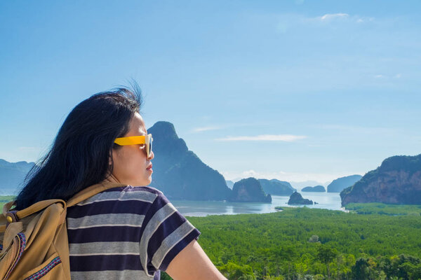 Happy young traveler woman backpacker looking at mountain with sea and enjoying a beautiful of nature at ,Freedom wanderlust,Khao Samed Nang Chee Viewpoint,Phang Nga,Thailand