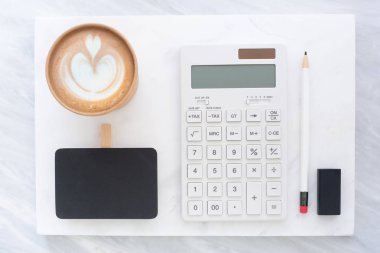 Beyaz Mermer blok ve gri mermer masa yığına üstten görünüm blackboard, kalem, silgi hesap makinesi ve kahve fincanı. Metin veya tasarım görüntülemek veya eklemek için şablon alay yat. İleti örneği öğe
