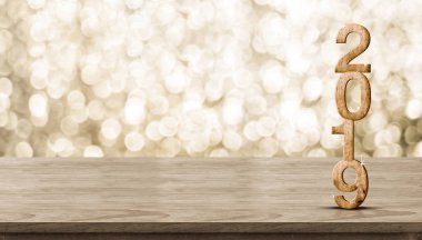 Mutlu yeni yıl 2019 ahşap altın bokeh arka plan, tatil bayram kutlama kavramı ile kahverengi ahşap masa parlayan yıldızı. Afiş sahte ürün veya tasarım içerik görünümü için