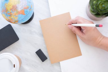 Mavi küre, yazı tahtası, kahve fincanı mermer table.new yıl çözünürlükleri kavramı ile kahverengi kağıt kalem yazma tutan el