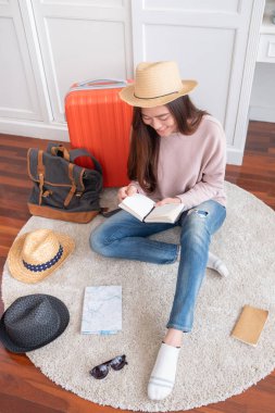 Genç Asyalı kadın seyahat tatil tatil home.backpacker seyahat kavramı, için portakal bavul şeyler hazırlamak