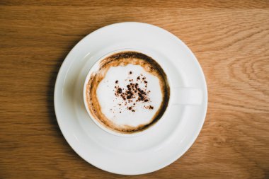 Cafe, gıda ve içecek, ahşap masa üzerinde sıcak cappuccino kahve Kupası üstten görünüm