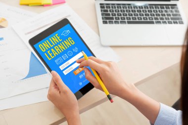 Kadın günlüğüne evde dijital tablet bilgisayar ile online öğrenme ders için omuz görünümü. E-öğrenme eğitim kavramı. Genel çalışma