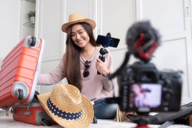 Asya genç kadın blogger ile tatil gezi home.online influcencer, sosyal medya kavramı üzerinde seyahat etmek hazırlık vlog video kaydı