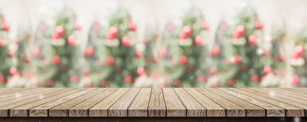 空の素朴な木の板テーブル トップ抽象的なぼかし赤いクリスマス ツリー装飾ボールと雪の落下背景ボケの光 冬休日背景に模擬製品やプロモーションの表示のバナーを — ストック写真