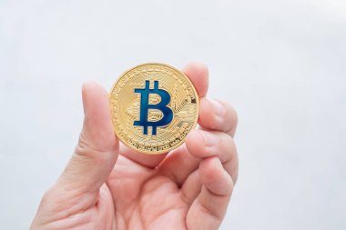 Altın bitcoin beyaz backgorund.digital currency.banking finans teknolojileri üzerinde tutan el