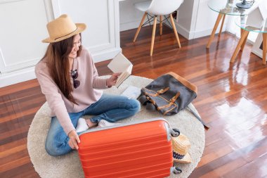 Genç Asyalı kadın seyahat tatil tatil home.backpacker seyahat kavramı, için portakal bavul şeyler hazırlamak