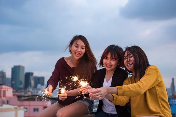 快乐组亚洲女孩朋友享受和玩烟火在屋顶党在黄昏日落 节日庆典节日 十几岁的生活方式 自由和乐趣 — 图库照片