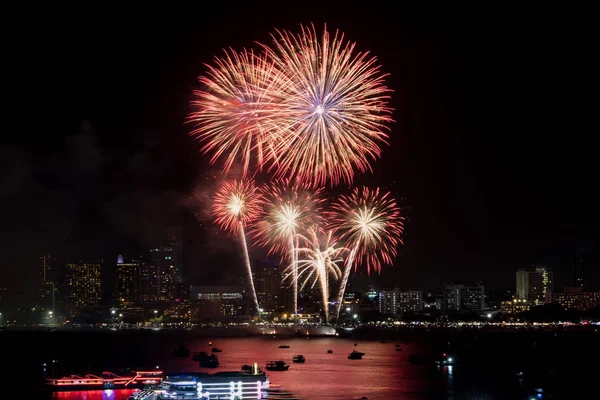 Fireworks explored over cityscape at night in sea port in Pattaya.Holiday festive celebration background