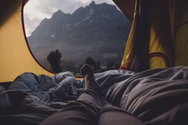 Yalan aşağı ve bacak üzerinde çadır ve mountain view adlı kamp tatil tatil günbatımı zaman seyir battaniyeye çapraz kadın sakin ol