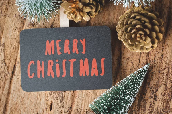 Kırmızı mutlu Noeller blackboard xmas ağacı ve altın çam kozalağı ile üstten görünüm grunge ahşap masa .winter tatil tebrik kartı