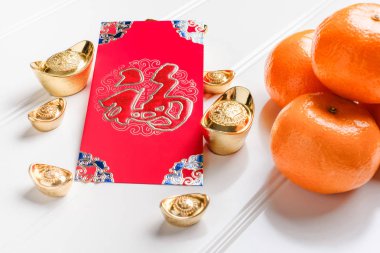 Üstten Görünüm Çin yeni yıl kırmızı zarf paket (ang pow) altın ingotlar ve mandalina Beyaz ahşap masa üstü üzerinde üzerinde Çince dil demek mutluluk örtmek ve külçe üzerinde varlıklı demek